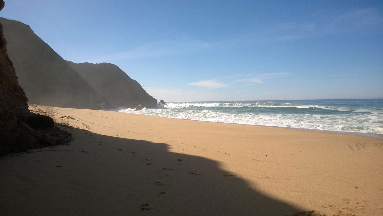 Photo of a beach along the mountains.