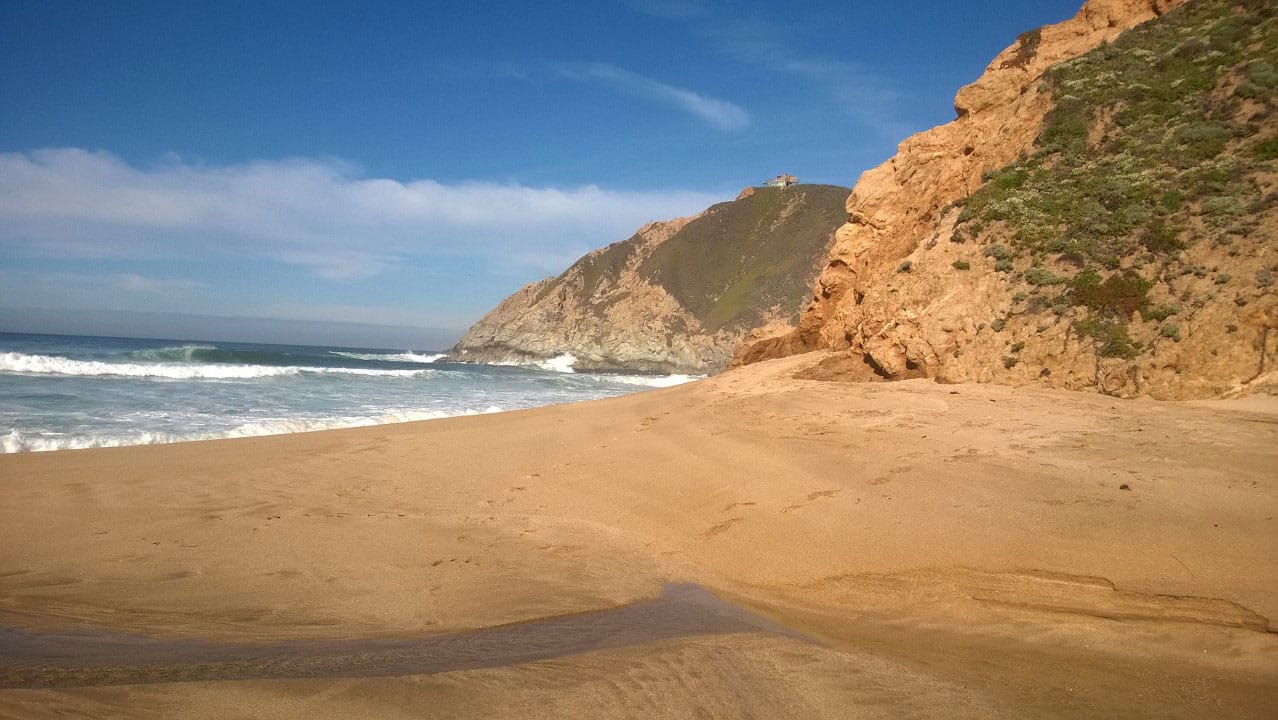 Photo of the beach along the mountains.