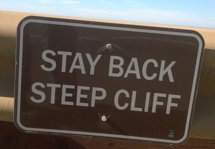 A sign that says stay back steep cliff