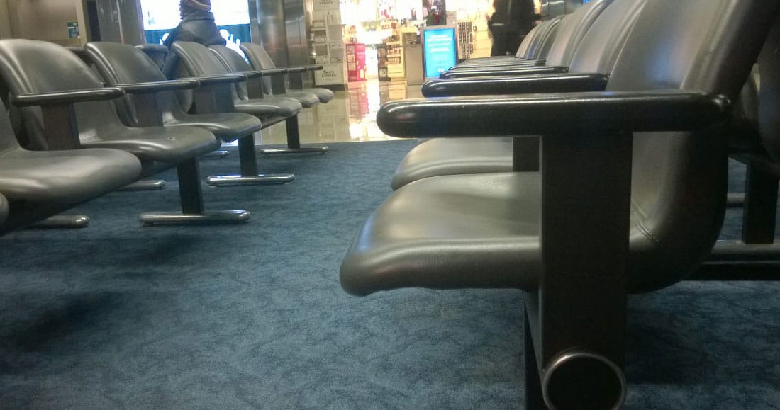 A photograph of a seats at a mostly empty airport